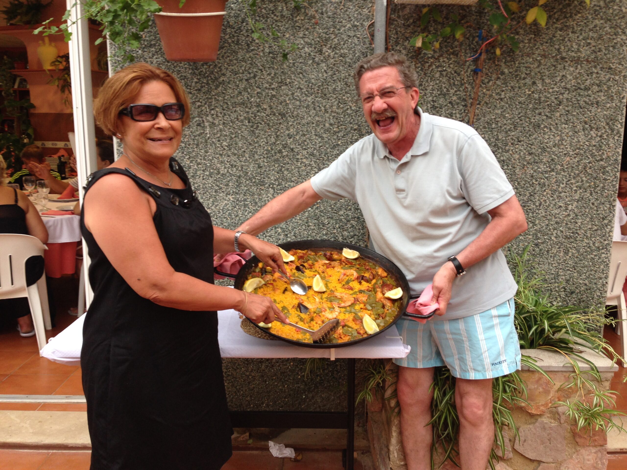 パエリアを持っているスペイン人の年配の夫婦