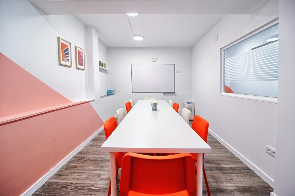 スペイン、バレンシアのスペイン語学校el carmen spanish schoolの人がいないピンクと白の壁の教室