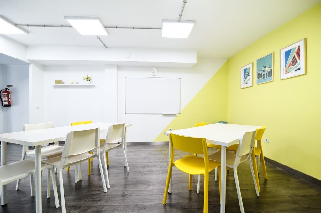 スペイン、バレンシアのスペイン語学校el carmen spanish schoolの人がいない黄色と白の壁の教室